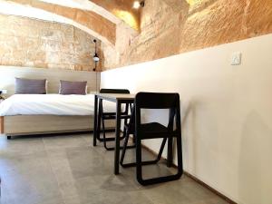 una camera da letto con un letto, un tavolo e delle sedie di Tide 21 Savynomad Harbour Residences Valletta a La Valletta