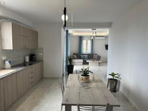a kitchen and living room with a wooden table in a room at Angel Homes in Plakias