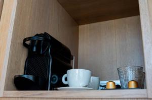 a shelf with a coffee maker and cups on it at Casa Bodhi Boutique Hotel & Spa in Marbella