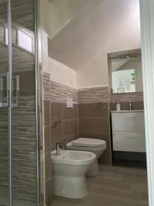 een badkamer met een toilet, een wastafel en een spiegel bij Maison Brancaleone in Barletta