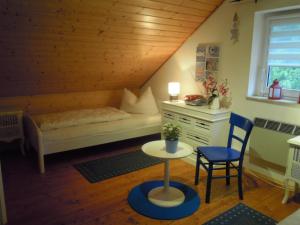 a bedroom with a bed and a table and a chair at Ferienhaus am Fleesensee in Silz