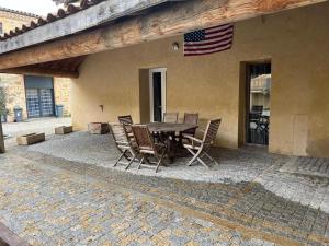 a patio with a table and chairs and an american flag at Beau logement 4 chambres in Roisey