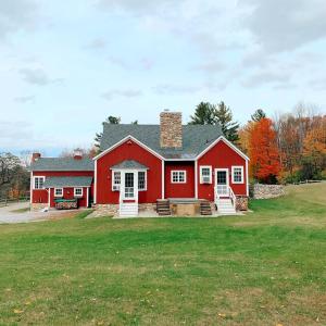 a red house with a large yard in front of it at Historic Renovated Barn at Boorn Brook Farm - Manchester Vermont in Manchester Center