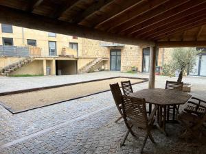 a patio with a table and chairs and a building at Beau logement 4 chambres in Roisey