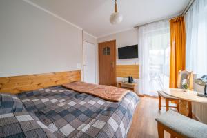 シュクラルスカ・ポレンバにあるPokoje Gościnne Magdaのベッドルーム1室(ベッド1台、デスク、テーブル付)