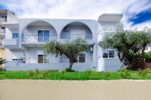a white house with trees in front of it at Aleanna Cozy Luxury Apartments in Rhodes Town