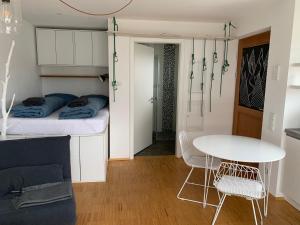 Cette petite chambre comprend un lit et une table. dans l'établissement Topmodernes Studio - Sommer im bayerischen Inntal, à Brannenburg