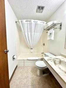 a bathroom with a toilet and a sink at Hotel 8 in Fergus Falls +11 photos