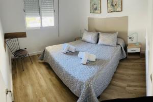 a bedroom with a bed with two towels on it at DELUX Salou in Salou