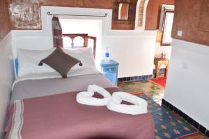 a bedroom with a bed with two towels on it at Kasbah Assafar in El Kelaa des Mgouna