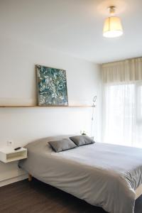a bedroom with a large bed and a window at Twenty Business Flats Le Mans Ouest in Le Mans
