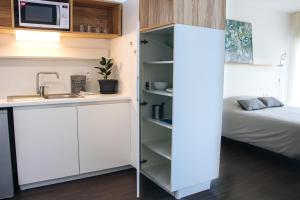 a small kitchen with a sink and a bed at Twenty Business Flats Le Mans Ouest in Le Mans