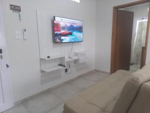 sala de estar con TV en una pared blanca en Alojamientobruisa en Lobos
