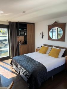 a bedroom with a large bed with yellow pillows at Morpheus in Amsterdam