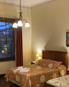 a bedroom with a bed and a window at Hostal Residencia en el Cerro in Valparaíso