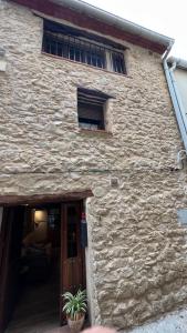 a stone building with a door and a window at La gallina in Arnés