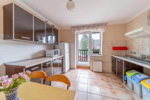 a kitchen with a table and chairs and a refrigerator at Pokoje Gościnne Magda in Szklarska Poręba