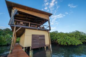 a house on a boat in the water at Roam Yoga & Wellness Lodge in Bocas Town