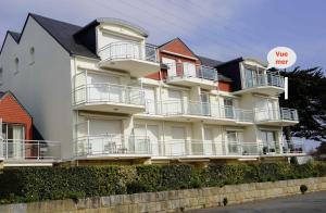 Ein weißes Gebäude mit Balkonen und einem Schild, das sagt, wir brauchen in der Unterkunft Grand appartement lumineux 4 pers. / vue mer / Wifi inclus in Quiberon