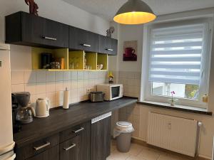 a kitchen with a counter with a microwave and a window at Pension 71 in Mittelbach