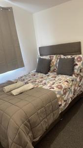 ein großes Bett mit einer Bettdecke in einem Schlafzimmer in der Unterkunft Small room in Horfield 3 in Bristol