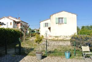 a house with a fence and a tree in a yard at maison spacieuse et lumineuse+ studio in Saint-Martin-de-Valgalgues