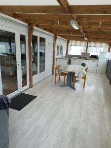 a living room with a table and a kitchen at Mobil-home dans camping calme in Pénestin