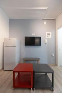 a living room with a refrigerator and a red table at Όμορφο στούντιο στο κέντρο της πόλης. in Larisa