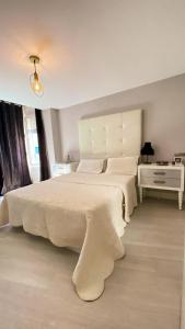 ein weißes Schlafzimmer mit 2 Betten und einer Lampe in der Unterkunft Penthouse Luxury Granada in Granada