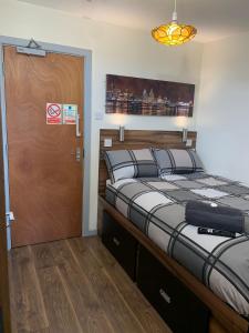 a bedroom with a large bed and a wooden door at The Liverpool Pod Travel Hostel in Liverpool