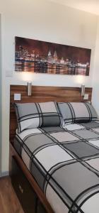a bedroom with a large bed with a wooden headboard at The Liverpool Pod Travel Hostel in Liverpool