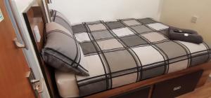 a bed with a black and white comforter at The Liverpool Pod Travel Hostel in Liverpool