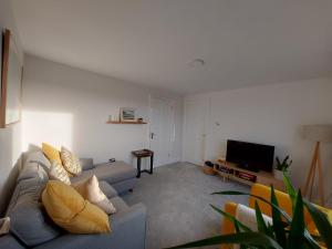 uma sala de estar com um sofá e uma televisão em Sunny Hill View em Lahinch