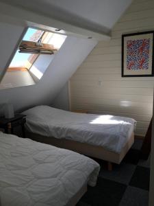 Schlafzimmer im Dachgeschoss mit 2 Betten und einem Fenster in der Unterkunft villa Flore, studio's in Bergen aan Zee