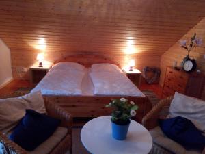 Schlafzimmer mit einem Bett mit 2 Stühlen und einem Tisch in der Unterkunft Ferienhaus am Fleesensee in Silz