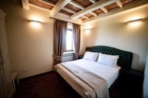 a bedroom with a bed with a green headboard and a window at Residenza Bellavita - Villa Luxury a 2 kilometri da Tropea in Gasponi