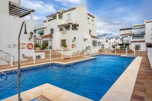 a swimming pool in front of a building at La Duquesa apartment with pool Ref M8 in Manilva