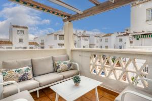 a couch on a balcony with a view of buildings at La Duquesa apartment with pool Ref M8 in Manilva