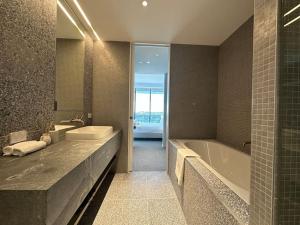 a bathroom with a tub and a sink and a bath tub at City view designed apartment in Bondi Junction in Sydney
