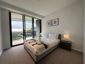 a bedroom with a large bed and a large window at City view designed apartment in Bondi Junction in Sydney