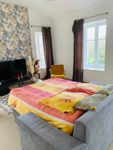 - une chambre avec un grand lit et un canapé dans l'établissement La roseraie de L arguenon, spacieux appartement centre ville, à Jugon Les Lacs