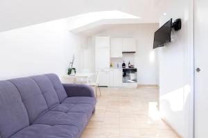 sala de estar con sofá púrpura y cocina en San Carlo Apartments, en Lugano