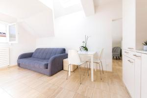 a living room with a blue couch and a table at San Carlo Apartments in Lugano