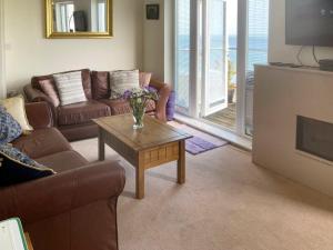 a living room with couches and a coffee table at Vue De Mer Ella in Shanklin