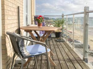 a wooden table and chairs on a balcony with a view at Vue De Mer Ella in Shanklin