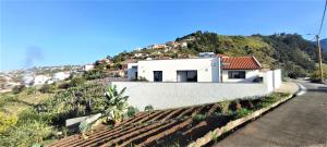 ein weißes Haus auf einem Hügel in der Unterkunft Casa Panorama Sol in Ponta do Sol