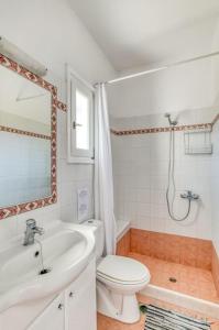 a white bathroom with a toilet and a sink at Thálassa House - Walking distance to Naoussa in Naousa