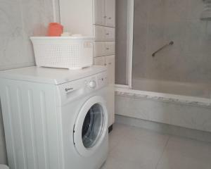 eine weiße Waschmaschine im Bad mit Badewanne in der Unterkunft Apartamento Teresa en Vilanova de Arousa in Pontevedra + 13 Fotos