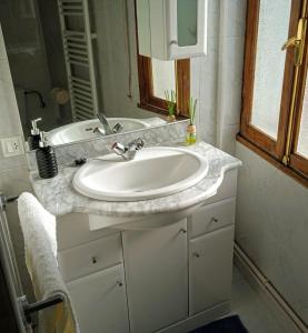 ein Badezimmer mit einem weißen Waschbecken und einem Spiegel in der Unterkunft Apartamento Teresa in Pontevedra