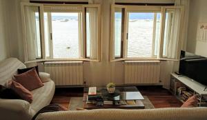 ein Wohnzimmer mit einem Sofa und 2 Fenstern in der Unterkunft Apartamento Teresa in Pontevedra